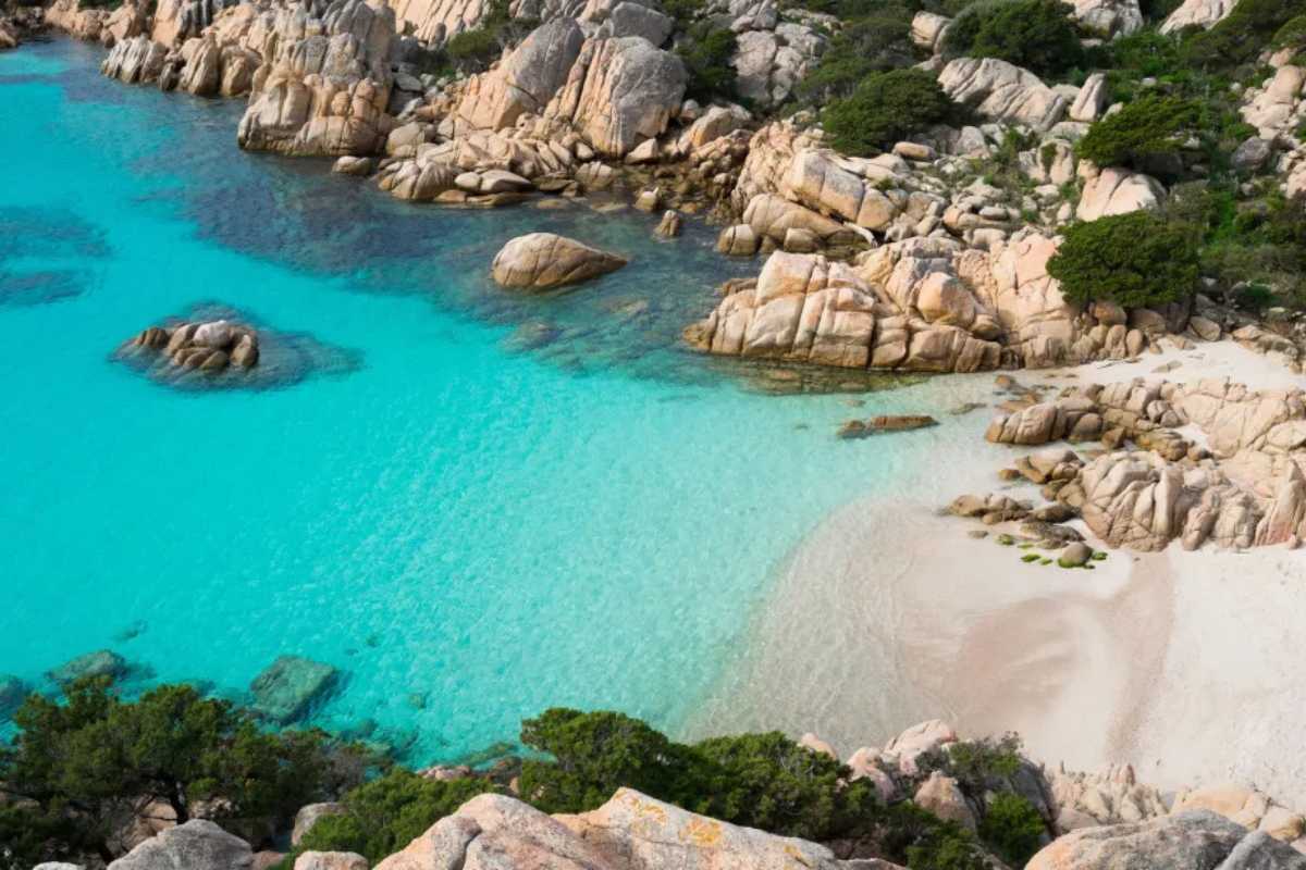 Sentiero escursionistico nel Parco Nazionale dell’Arcipelago di La Maddalena, con vegetazione mediterranea, rocce di granito rosa e vista sulle isole circostanti, atmosfera primaverile e famiglie in cammino