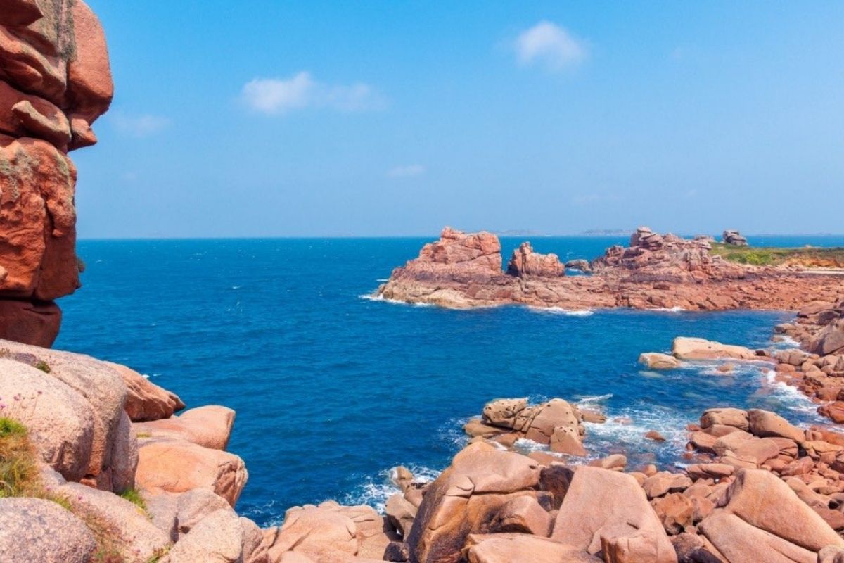 Panorama sulla costa di Cala Francese con le tipiche rocce di granito rosa, mare trasparente, sentiero e vegetazione mediterranea, perfetto per illustrare la bellezza naturalistica di La Maddalena